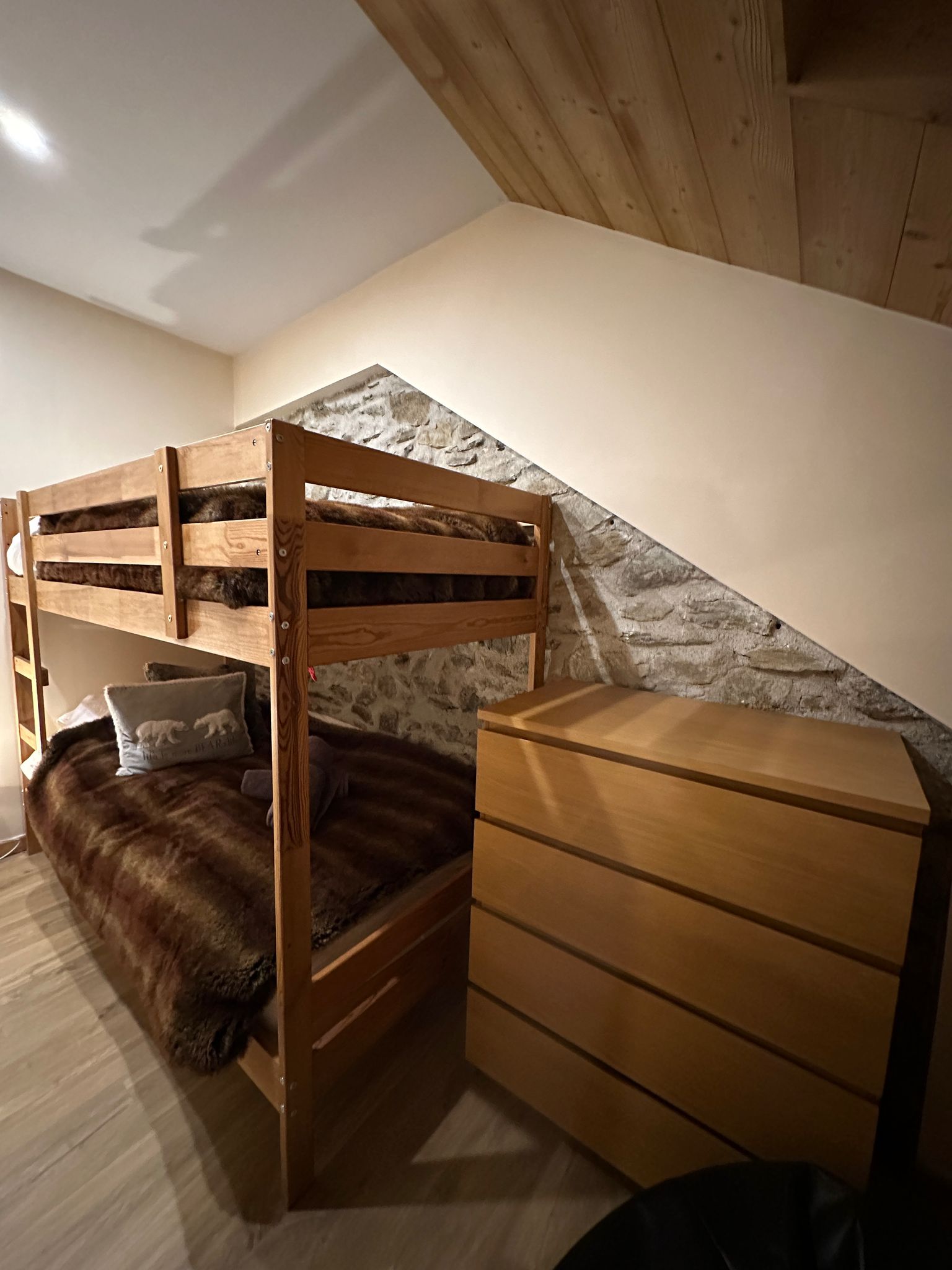 Bunk room with stone wall